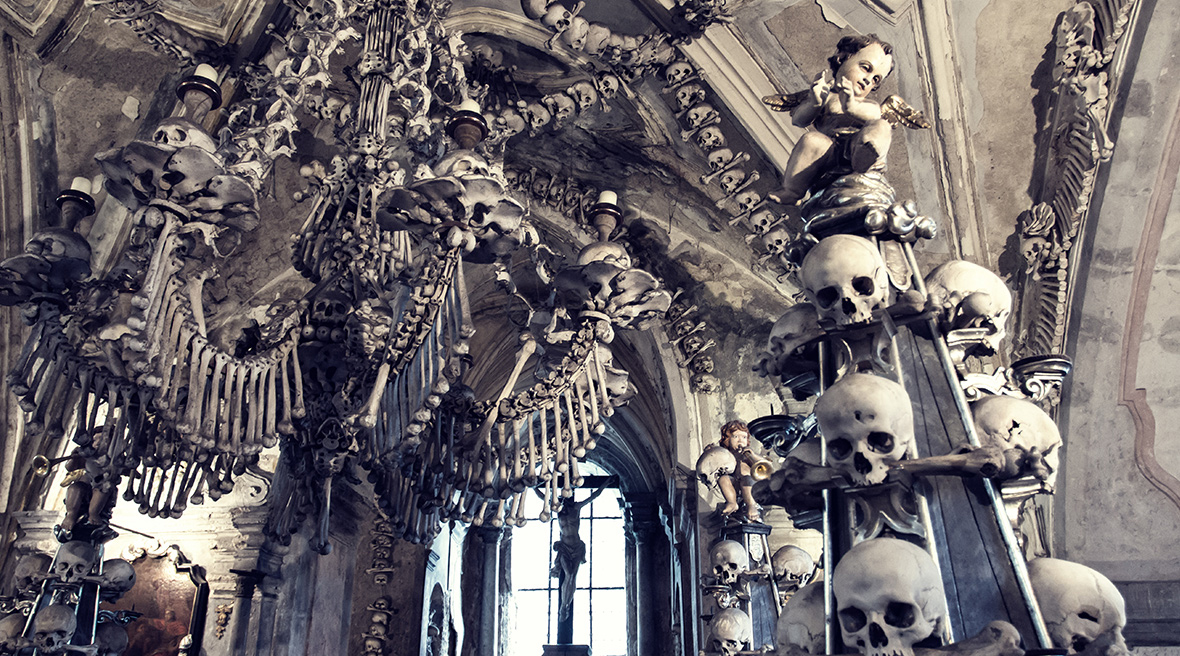 A large arched window surrounded by skeletons and skulls